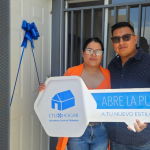 Pareja feliz sosteniendo una llave simbólica frente a su nuevo hogar de CTU Hogar en Chihuahua.