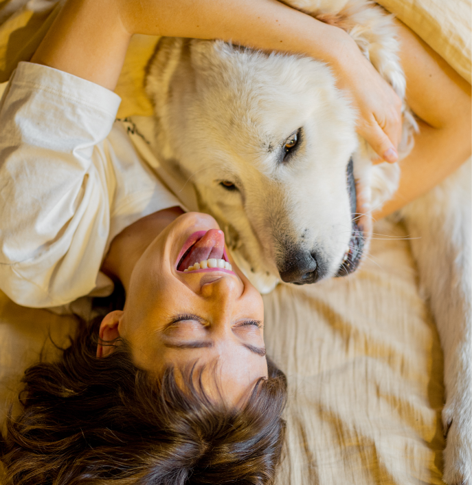 Mujer con perro en una cama